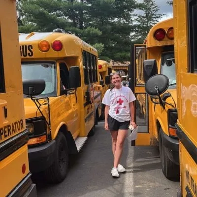 A girl stood next to a bus